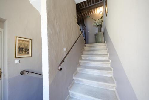 a staircase in a house with white walls and white steps at Chambres du Vieux Bistrot in Cabrières-dʼAvignon