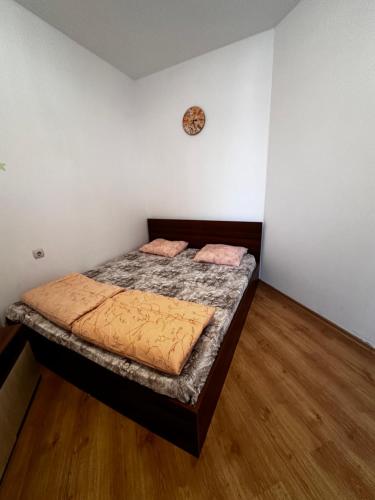 a bedroom with a bed in a room with wooden floors at Central Apartment Sunny beach in Sunny Beach