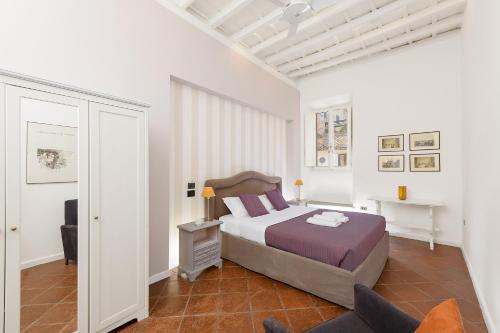 a white bedroom with a bed and a chair at Bernini al Borgo in Rome