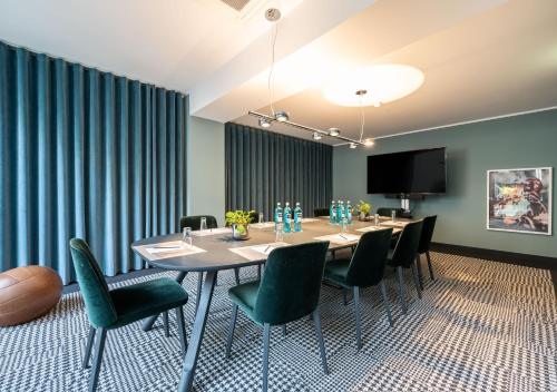 a conference room with a long table and chairs at The Midtown Hotel in Cologne