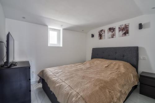 une chambre blanche avec un lit et une télévision dans l'établissement Cozy Moderne - Studio rénové 4p, à Bois-dʼArcy