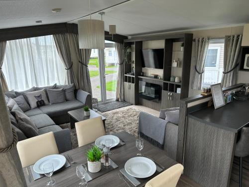 a living room with a couch and a dining room at Church Farm Holiday Home in Pagham