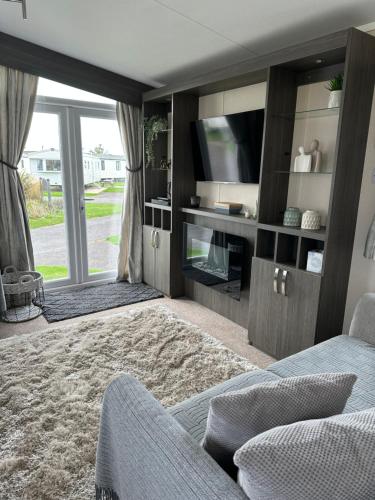 a living room with a tv and a couch at Church Farm Holiday Home in Pagham