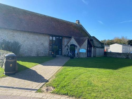 an old stone building with a grass yard at Church Farm Holiday Home in Pagham