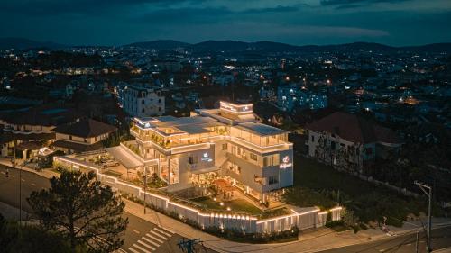 a large white building with lights on it at night at California Hotel in Da Lat