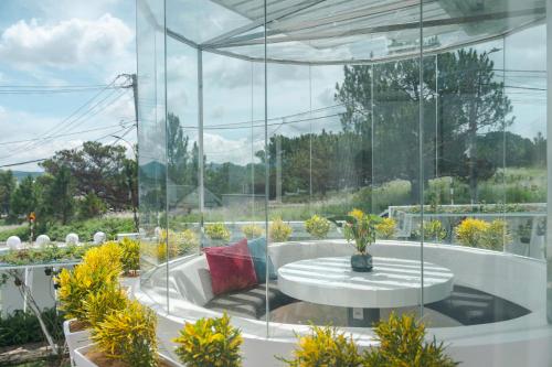 a patio with a round table and a large window at California Hotel in Da Lat