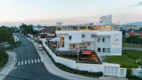 a white building on the side of a road at California Hotel in Da Lat