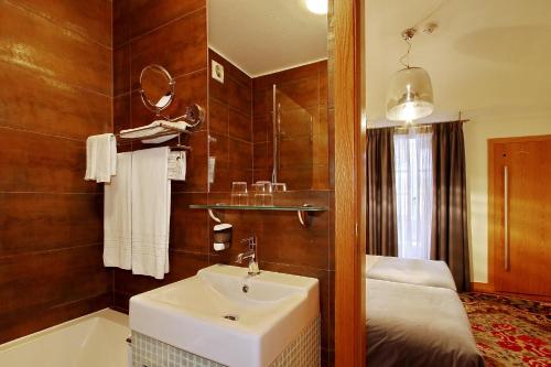 a bathroom with a sink and a bath tub at Hotel Mestre de Avis in Guimarães