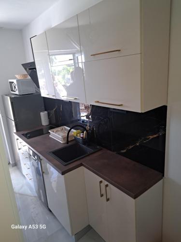 a kitchen with white cabinets and a sink at Josip in Nin
