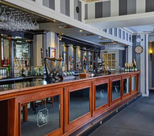 a bar with a large wooden counter in a room at Royal Beacon Hotel in Exmouth