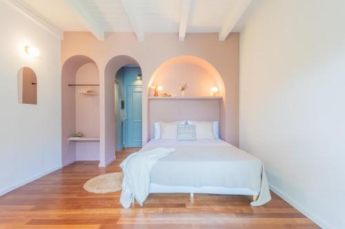 a bedroom with a white bed in a room with arches at OC Lake Love by Rent All Como in Laglio