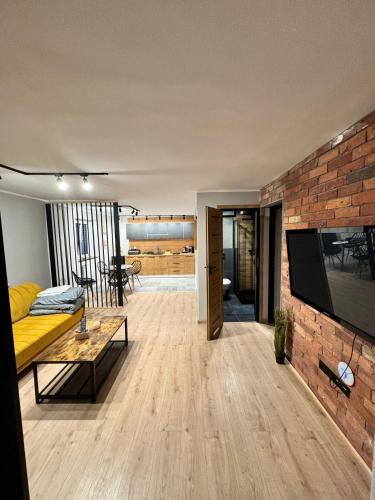 a living room with a couch and a brick wall at Apartamenty Stodoła in Kajkowo