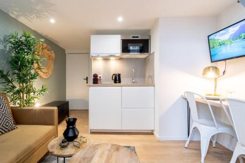 un salon avec un canapé, une table et une cuisine dans l'établissement Lille Beaux Arts : studio équipé en mezzanine, à Lille