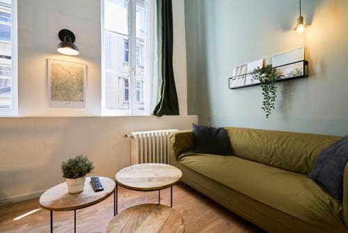 - un salon avec un canapé vert et 2 tables dans l'établissement Lille Beaux Arts : studio équipé en mezzanine, à Lille