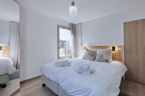 - une chambre avec un grand lit blanc et des oreillers blancs dans l'établissement Alpina - Neuf et Skis aux pieds, à Saint-Gervais-les-Bains