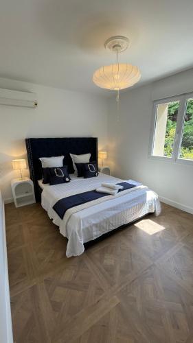 une chambre avec un grand lit et un lustre dans l'établissement Mas la Rigaude, à Livron-sur-Drôme