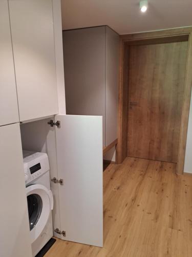 a laundry room with a washing machine and a door at Pension Baldauf - Dorf 31 in Kleinarl