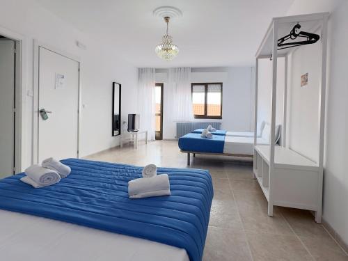1 dormitorio con 2 camas y sábanas azules en Complejo Tamanaco Illa de Arousa 3000, en A Illa de Arousa