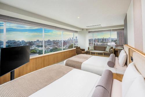 a hotel room with two beds and a flat screen tv at ART HOTEL Nippori Lungwood in Tokyo