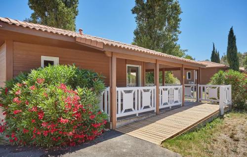 a small house with a wooden deck and flowers at Résidence Odalys Shangri-la in Carnoux