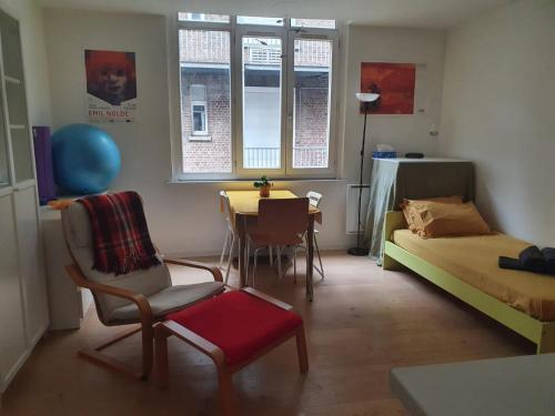 un salon avec un lit, une table et des chaises dans l'établissement Flat Sainte Anne Lille, à Lille
