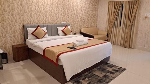 a hotel room with a bed and a chair at Hotel Stalwart Jajati in Bhubaneshwar