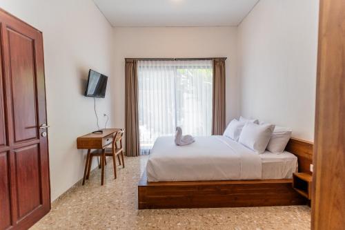 a bedroom with a bed and a desk and a window at Samada Work Life Canggu in Canggu