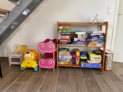 une étagère avec des livres et des jouets dans une chambre dans l'établissement Gîte climatisé DUNE ET PLAGE jqà 12 personnes, à Saint-Jean-de-Monts