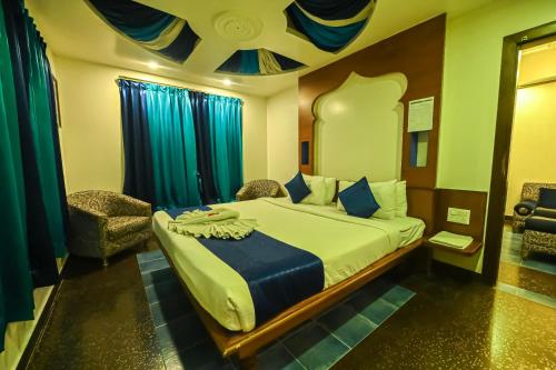 a bedroom with a bed and a chair at Sepoy Grande Mysore in Mysore