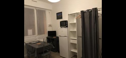 Cette chambre comprend un réfrigérateur et un bureau. dans l'établissement Studio 11 Malo les bains proche plage, à Dunkerque