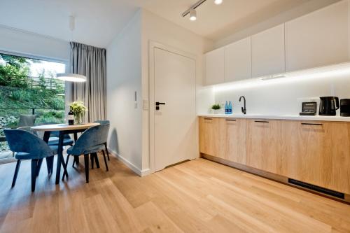 a kitchen and dining room with a table and chairs at Aparthotel Anchoria BlueApart in Mechelinki