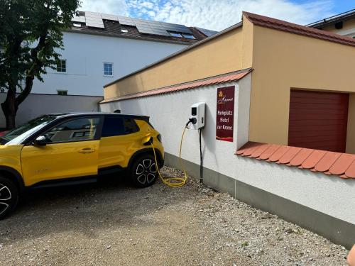 a yellow car parked next to a building with a meter at Hotel Zur Krone in Beilngries