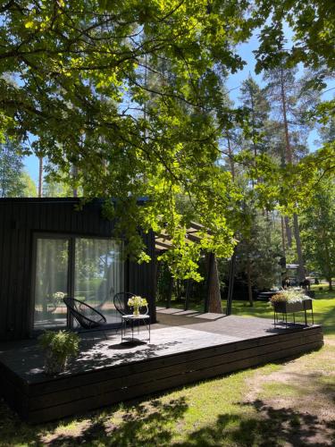 a house with two tables on a patio at Camping Milk in Usmenieki