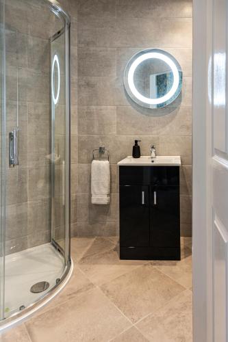 a bathroom with a shower and a sink and a mirror at No 1 Killarney Holiday Village Vacation Home in Killarney