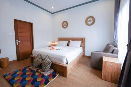 TampaksiringにあるUrbanview Villa Pondok Uma Sari near Ubudのベッドルーム1室(ベッド1台、椅子、ソファ付)