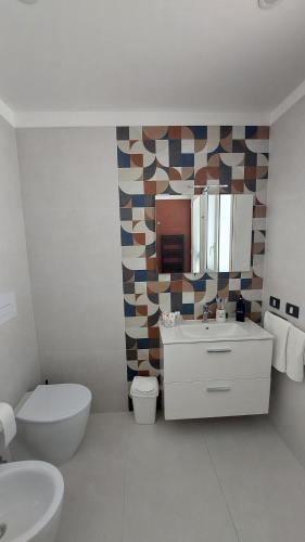 a bathroom with a toilet sink and a mirror at Terrazza Bianca in Vittoria