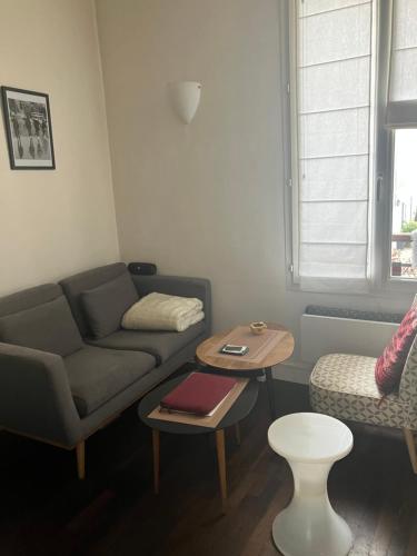 un salon avec un canapé et une table dans l'établissement Appartement 9e, à Paris