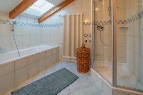 a bathroom with a shower and a tub and a sink at Ferienwohnung Westernberg in Ruhpolding