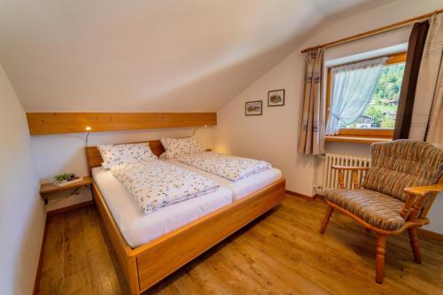 a bedroom with a bed and a chair and a window at Ferienwohnung Westernberg in Ruhpolding