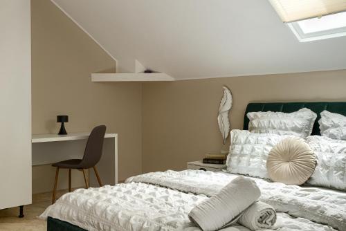 a bedroom with a bed and a desk with a chair at Sika Grand Palladium Garden & Spa Central Apartment Arad in Arad