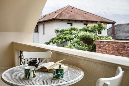 a table on a balcony with a view of a building at Sika Grand Palladium Garden & Spa Central Apartment Arad in Arad