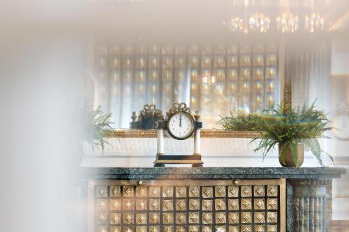 a clock sitting on top of a table in a room at Hotel Astoria Vienna, Curio Collection by Hilton in Vienna