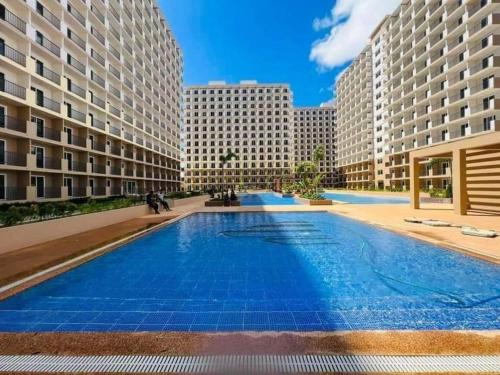 a large swimming pool in a building with tall buildings at Lai Stay in Lapu Lapu City