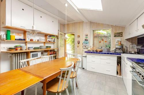 une grande cuisine avec une table et des chaises en bois dans l'établissement Maison La campagne à Paris, à Le Pré-Saint-Gervais