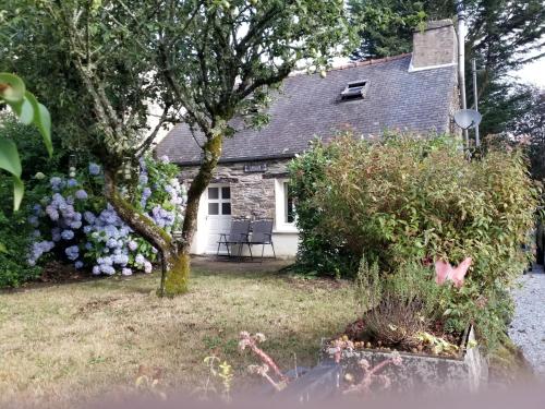 a stone house with flowers in front of it at KerJean in Caurel