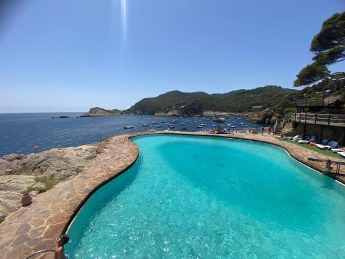a swimming pool next to a body of water at El 66 de Cap Sa Sal in Begur