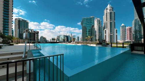 a large swimming pool with a view of a city at City Views, Pool & Gym Near Iconic Burj Khalifa in Dubai