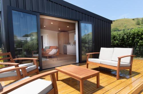 a screened in deck with chairs and a table at Salt Guesthouse in Gisborne