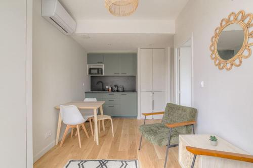 une cuisine et une salle à manger avec une table et des chaises dans l'établissement Appartement neuf, clim et parking, Caluire-Dombes, à Caluire-et-Cuire