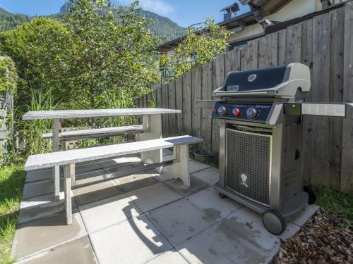 a grill and a picnic table next to a bench at Alpegg Chalets in Waidring